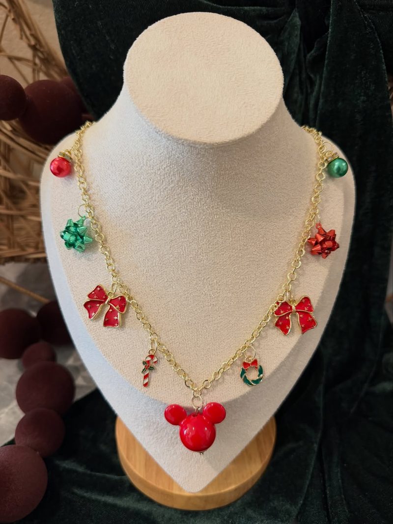 A finished custom gold necklace with red bows and holiday charms